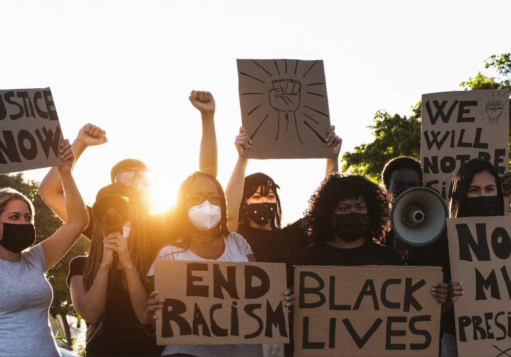 A diverse group of individuals holding signs with messages such as 